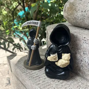 Dettaglio di una statuetta della morte con una tazza di caffè e un gatto giallo