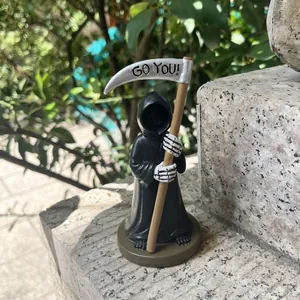 Dettaglio della statuetta in resina del Tristo Mietitore con incisione Go You sulla falce
