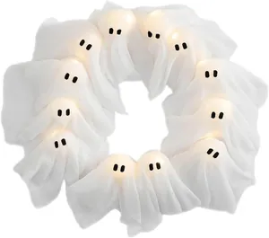 Detail of eleven glowing Halloween ghost ornaments with warm LED lights and white fabric