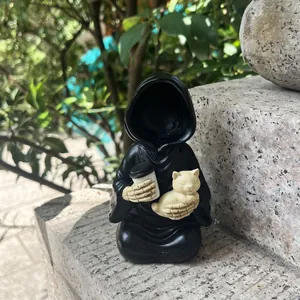 Dettaglio della statuetta del Tristo Mietitore con gatto e caffè su una pietra