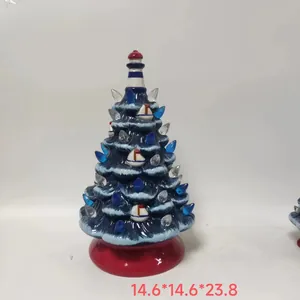 Close-up of blue ceramic Christmas tree featuring white sailboats and lighthouse top
