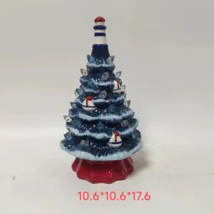 Detailed view of nautical ceramic Christmas tree with lighthouse topper and sailboat decor