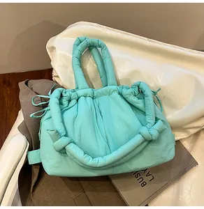Close-up of mint green quilted puffer tote bag featuring soft knotted rope shoulder straps