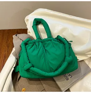 Detail of green quilted puffer tote bag with thick padded handles and drawstring closure