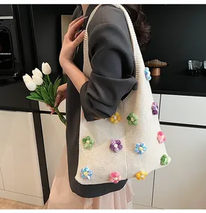 Détail du sac cabas en tricot avec fleurs 3D au crochet et texture tissée douce
