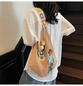 Hobo style knit shoulder bag featuring colorful crochet sunflower patterns and casual drape