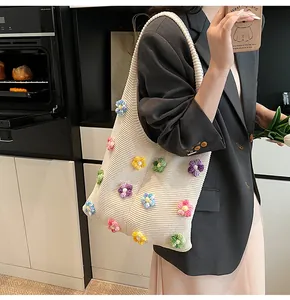 Detail der Strick-Tote-Bag mit bunten 3D-Häkelblumen und vertikaler Rippenstruktur