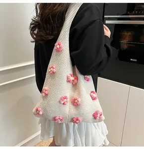 Detail der Stricktasche mit beigem Rippmuster und dreidimensionalen rosa Häkelblumen