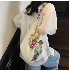 Detail of white crochet tote bag featuring colorful floral straps and cartoon character patch