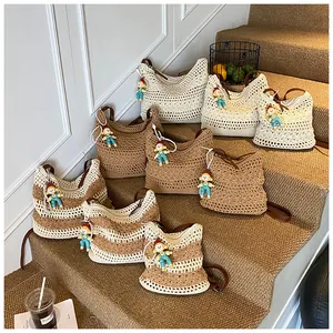 Detail of hand-woven crochet shoulder bags in cream and khaki with cute doll charms