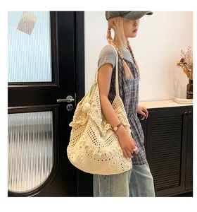 Close-up of cream knit tote bag with intricate openwork crochet and scalloped edges