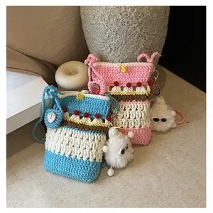 Detail of handmade crochet crossbody bags with cute strawberry and plush doll pendants