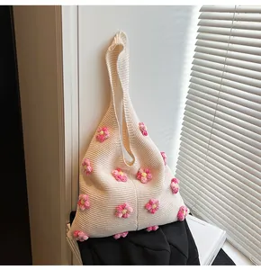 Detailansicht der cremefarbenen Stricktasche mit rosa und gelben floralen Akzenten