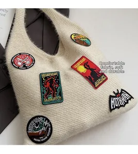 Macro shot of off-white knitted tote bag featuring cryptid embroidery and soft plush texture