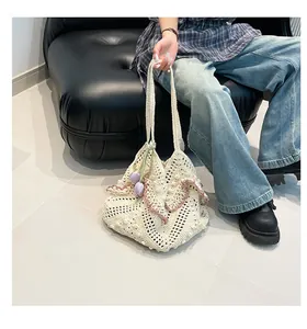 Close-up of cream crochet tote bag with pink scalloped trim and tulip flower charm