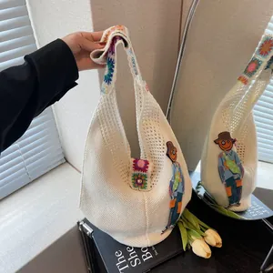 Detail of handmade crochet hobo bag with sunflower patches and colorful knit strap
