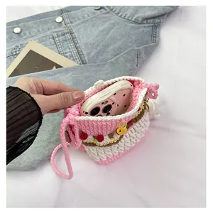 Detailed view of handmade crochet crossbody bag fitting a pink smartphone inside