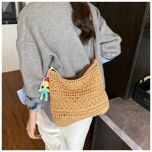 Detail of the woven cotton beach bag with crochet texture and a cute charm