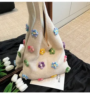 Détail de la maille et fleurs 3D colorées sur un sac cabas en coton crocheté beige
