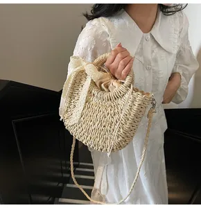 Détail d'un sac en paille tissé à la main avec un nœud en dentelle blanche et doublure