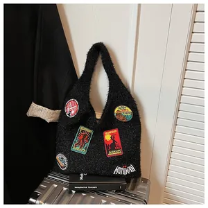 Détail du sac en maille noire duveteuse avec écussons brodés d'animaux mystérieux vintage