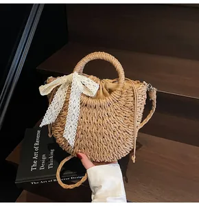 Détail du sac en paille tressée avec nœud en dentelle et doublure sur bois foncé