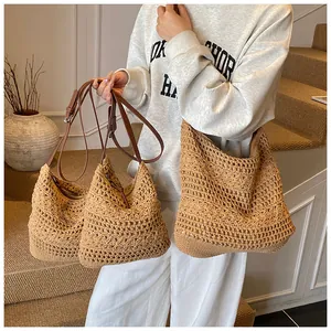 Detailed close-up of hollow weave pattern and adjustable brown leather strap on tote bag