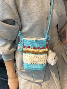 Colorful handmade crochet crossbody bag with strawberry decor and floral knit patterns