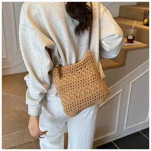 Close-up of khaki woven cotton beach bag with hollow crochet pattern and leather strap