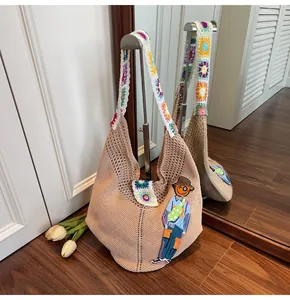 Detail of beige crochet tote with cartoon embroidery and colorful granny square straps