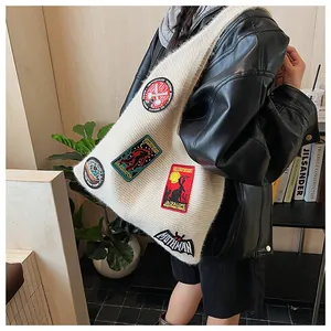 Détail du sac fourre-tout en tricot crème avec broderies colorées de créatures mythiques