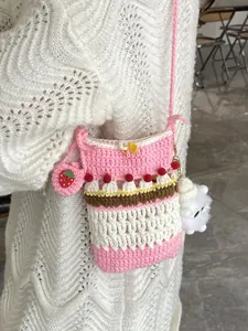 Handmade crochet cake crossbody bag with strawberry charm and pink knit details