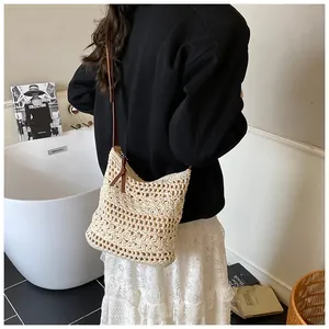 Detail view of the hollow flower crochet texture on a cream woven shoulder bag