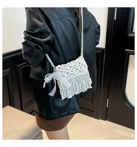 Detail der weißen Boho-Webtasche mit zarter Spitzenschleife, Perlen und Fransenquasten