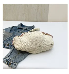 Detail of hollow-out knit texture on cream cotton shoulder bag with purple wavy trim