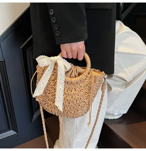Détail du sac en paille tissé main avec nœud en dentelle blanche et doublure à cordon serrage