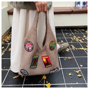 Détail du sac cabas en tricot kaki avec écussons rétro de créatures et texture douce