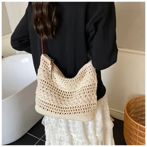 Detail of cream crochet knit shoulder bag with floral pattern and brown leather strap