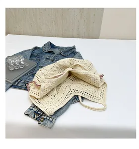Detail of hollow knit cotton tote bag with purple trim over denim jacket
