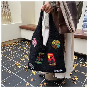 Détail du sac à bandoulière en fausse fourrure noire avec patchs brodés vintage