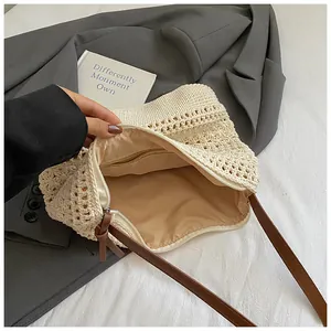 Detail of crochet weave pattern with zipper closure and brown strap on beige beach bag