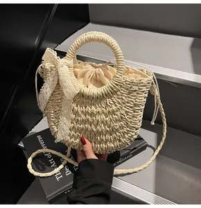 Détail du sac de plage en paille avec nœud en dentelle et pochette intérieure
