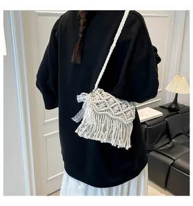 Detail der weißen handgefertigten Makramee-Tasche mit Spitzenschleife und Fransen