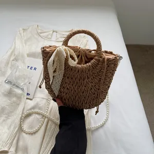 Détail du sac en paille avec nœud en dentelle beige et doublure à cordon ajustable