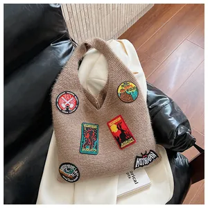 Détail du sac cabas en tricot kaki avec broderies colorées et texture épaisse