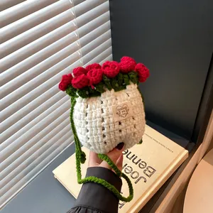 Détail du sac seau au crochet avec roses rouges et bandoulière verte tissée