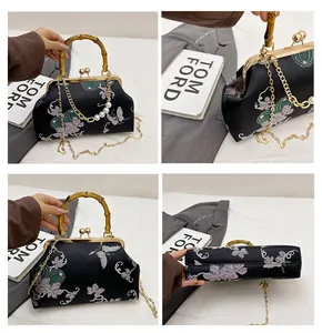 Detail van bamboe handvat, bloemen-vlinderprint en gouden parelketting op de schelptas