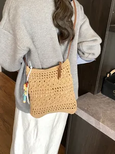 Large woven cotton shoulder bag with hollow geometric patterns and a creative pendant