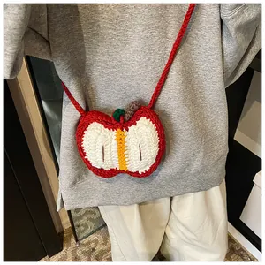 Close-up of handmade crochet apple-shaped crossbody bag with detailed knit texture