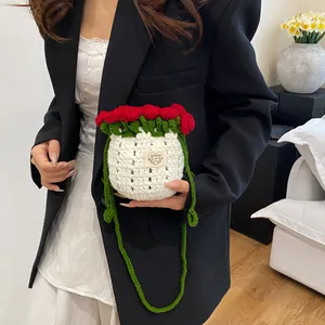 Détail du sac seau fait main au crochet avec roses 3D rouges et textures de feuilles